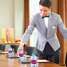 Man Arranging Bottled Water in Meeting Room